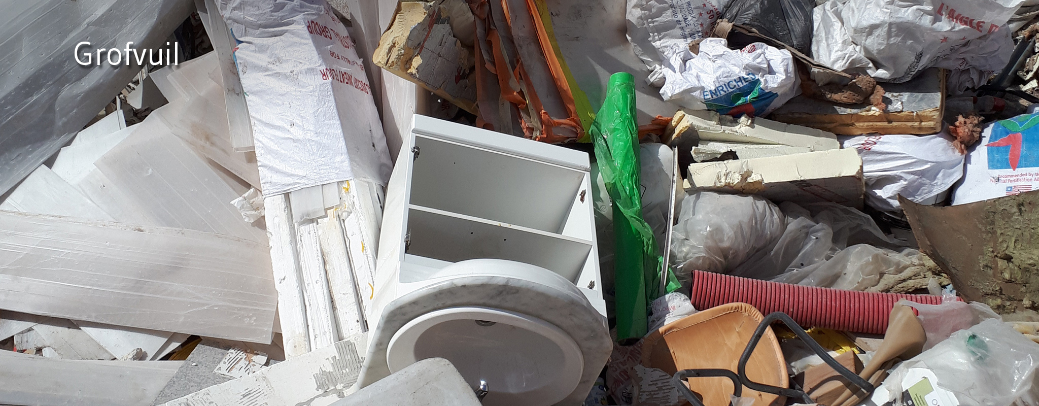 Kapotte meubelen, buizen, plastiek zakken gestort in containerpark