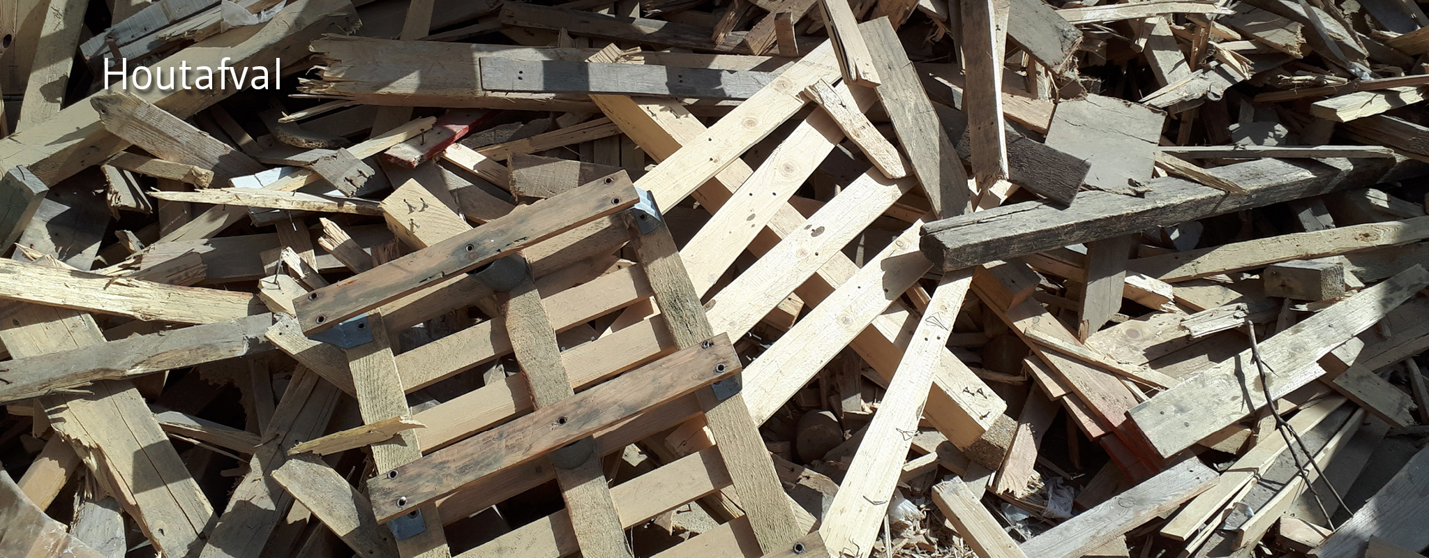 Oude palletten en houten balken klaar voor recyclage
