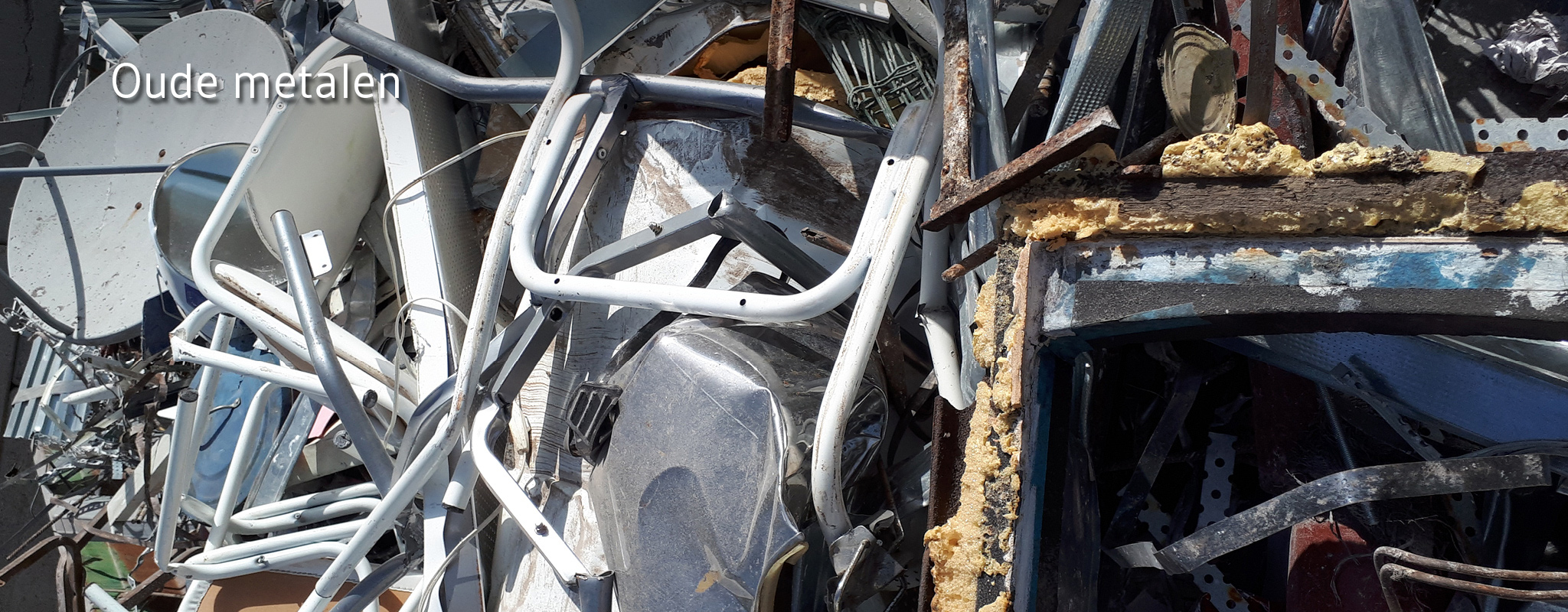Metalen voorwerpen en buizen in grote afvalcontainer